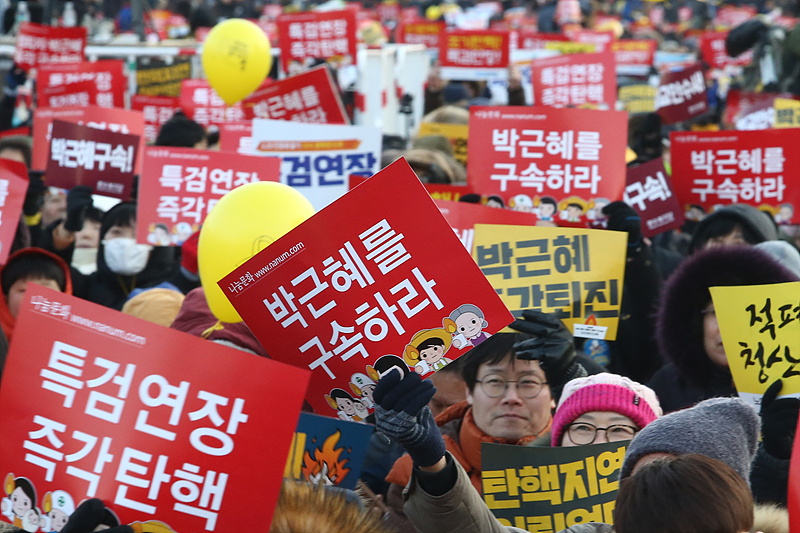 18일 서울 광화문광장에서 열린 제16차 박근혜 퇴진 촉구 촛불집회에 참가한 시민들이 특검 연장과 박근혜 구속을 촉구하는 손피켓을 들고 있다.