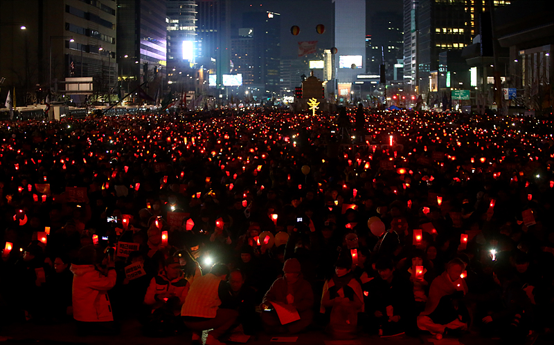 4일 오후 서울 광화문광장에서 열린 박근혜 대통령 탄핵을 촉구하는 19차 촛불집회에 참가한 시민들이 박근혜 저권의 퇴진을 촉구하는 레드카드를 상징하며 빨간색 촛불을 들고 있다.