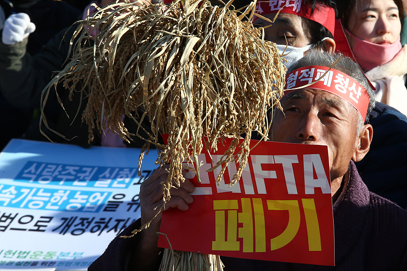 지난해 11월 18일 오후 서울 여의도 문화마당에서 열린 ‘농민 권리와 먹거리 기본권 실현을 위한 전국 농민대회’에 참석한 농민이 한미FTA 폐지를 촉구하는 손피켓을 들고 있다.