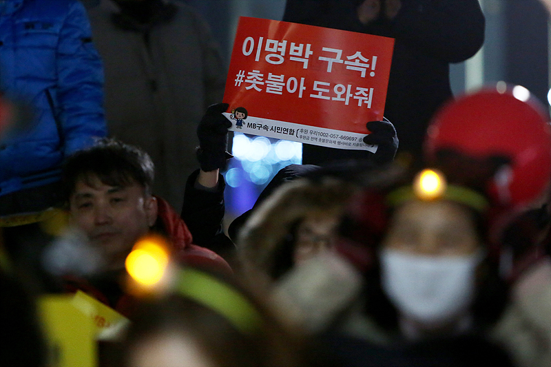 20일 오후 서울 광화문광장에서 열린 ‘이명박 전 대통령 수사 촉구 문화제’ 에서 시민들이 이명박 전 대통령의 구속을 촉구하는 손피켓을 들고 있다.