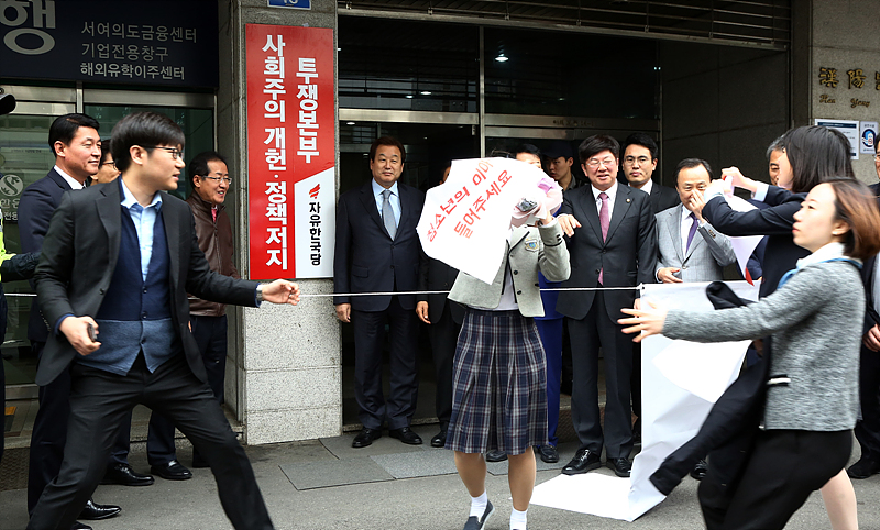 서울 여의도 자유한국당 중앙당사에서 열린 ‘사회주의 개헌·정책 저지 투쟁본부 현판 제막식’에서 홍준표 대표 및 김문수 서울시장 후보 등이 선거연령 하향을 촉구하는 청소년들의 기습 피켓 시위를 바라보고 있다.