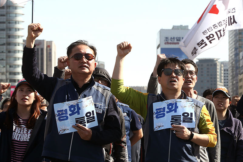 21일 오후 서울 광호문광장에서 열린 민주노총 주최 ‘4·21 노동자 평화통일 한마당’에서 참석자들이 평화통일 손피켓을 들고 구호를 외치고 있다.