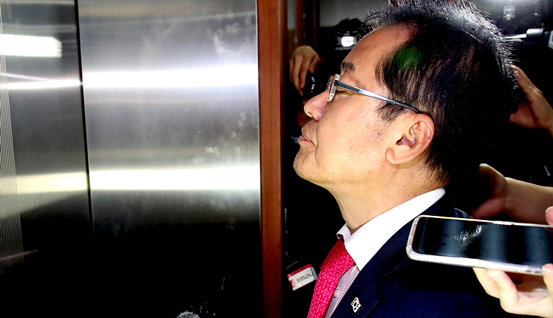 자유한국당 홍준표 대표가 14일 오후 서울 여의도 중앙당사에서 선거 참패의 책임을 지고 대표직 사퇴 의사를 밝힌 뒤 당사를 떠나기 위해서 승강기 앞에서 기다리고 있다.