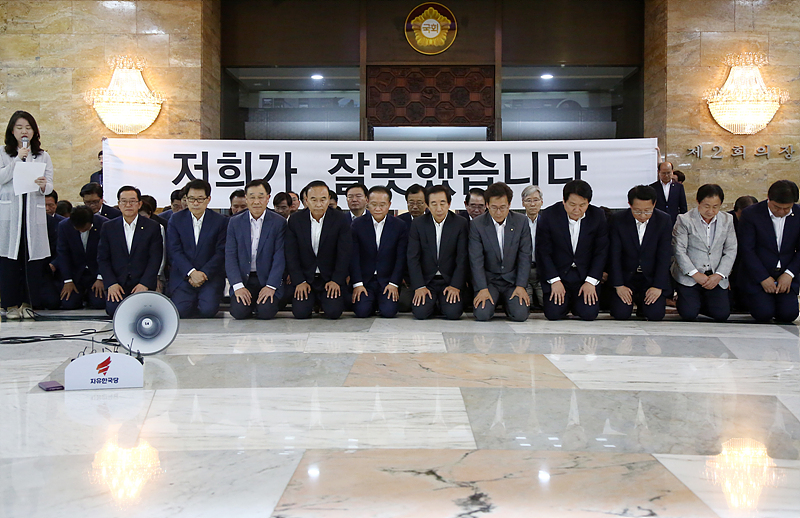 자유한국당 김성태 대표 권한대행 겸 원내대표와 소속 의원들이 15일 오후 국회 예결위장에서 열린 비상의원총회를 마치고 본청 중앙홀에서 무릎을 꿇고 선거 패배에 따른 대국민 사과를 하고 있다.