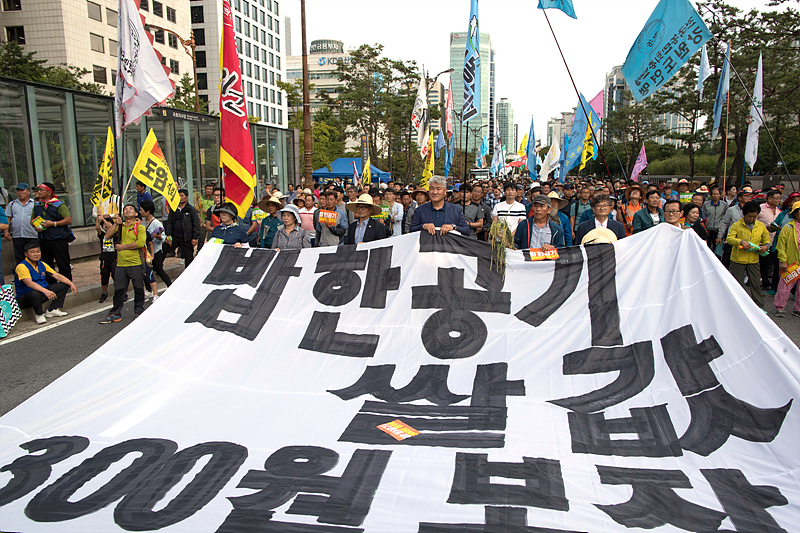 11일 서울 여의도 산업은행 앞에서 열린 ‘백남기 정신계승! 문재인정부 농정 규탄! 전국농민대회’ 참석자들이 쌀값 안정화를 촉구하며 행진하고 있다.