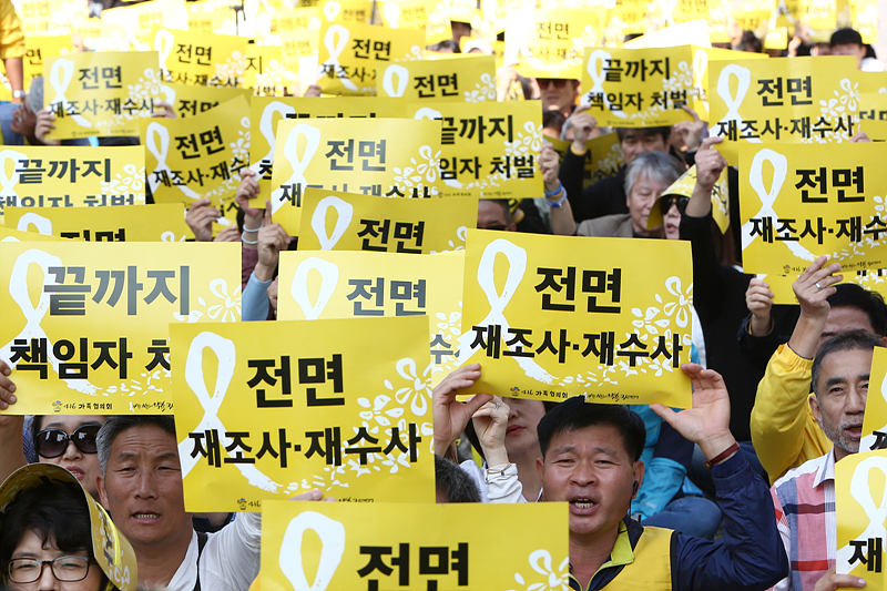 13일 서울 광화문 416광장에서 열린 ‘세월호참사 전면 재조사·재수사 촉구 국민대회’에서 유가족들과 시민들이 전면 제조사를 촉구하는 손피켓을 들고 구호를 외치고 있다.