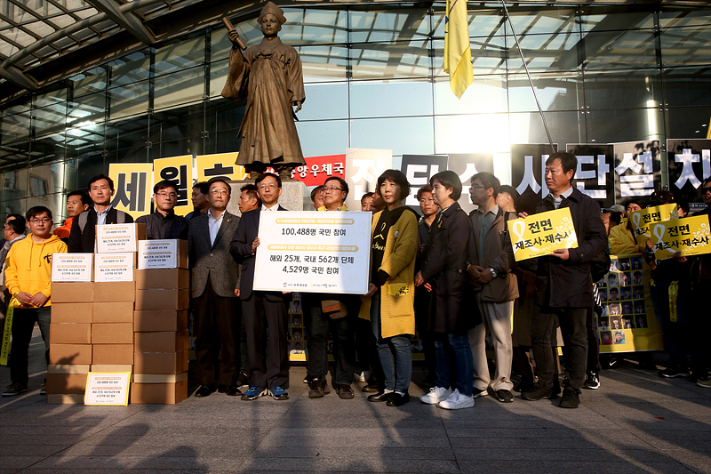 13일 서울 광화문 416광장에서 열린 ‘세월호참사 전면 재조사·재수사 촉구 국민대회’를 마친 유가족들과 시민들이 세월호특조위 사무실 앞에서 장완익 사회적참사특별조사위원장에게 국민들의 진상규명요구 서명지를 전달하고 있다.