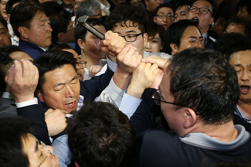 26일 새벽 국회 의안관 앞에서 더불어민주당 당직자들이 의안과 문을 열기위해 사용한 쇠지레를 자유한국당 당직자들이 뺏고 있다.