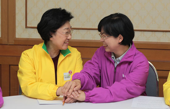 서로의 손을 잡고 있는 한명숙, 이정희