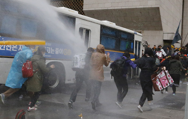 18일 오후 서울 세종문화회관 앞에서 세월호 참사 범국민대회 참가자들이 광화문 앞에서 농성 중인 세월호 유가족들을 만나러 가려 하자 경찰이 물대포를 쏘고 있다.