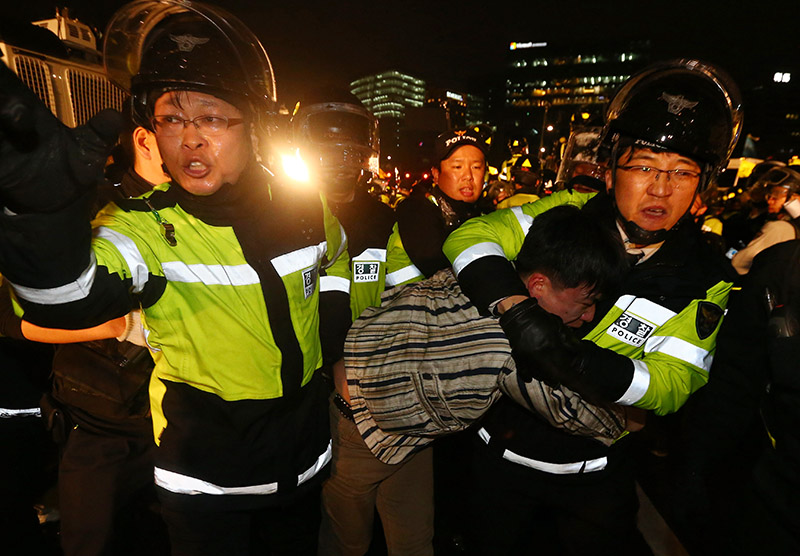 서울 경복궁 동십자각 앞에서 세월호 범국민대회 참가자가 광화문 누각 앞에서 농성 중인 세월호 유가족을 만나기 위해 경찰과 대치하다 연행되고 있다.(자료사진)
