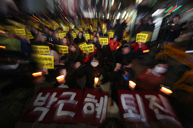 21일 오후 서울 태평로 파이낸스 빌딩 앞에서 열린 살인진압 경찰청장 파면 촉구, 백남기 농민 쾌유 기원 시민대회 참가자들이 손피켓과 촛불을 들고 구호를 외치고 있다.