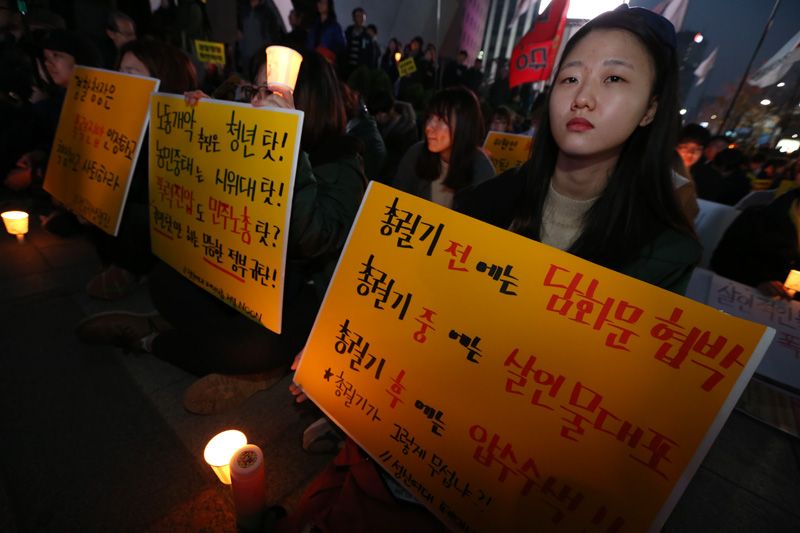 21일 오후 서울 태평로 파이낸스 빌딩 앞에서 열린 살인진압 경찰청장 파면 촉구, 백남기 농민 쾌유 기원 시민대회 참가자들이 피켓을 들고 있다.