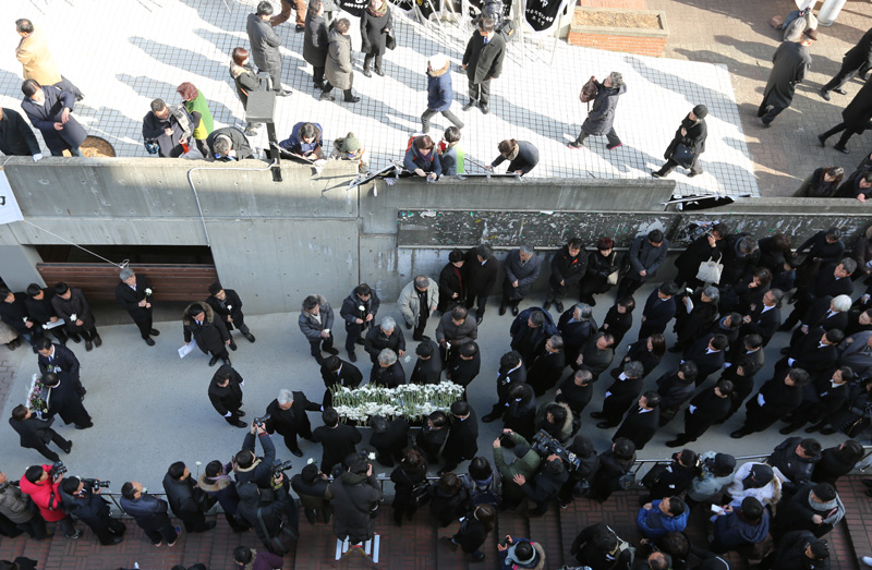 18일 서울 항동 성공회대학교에서 엄수된 고(故) 신영복 성공회대 석좌교수의 영결식을 마치고 고인의 영정과 유해가 운구 중 조문객들이 고인에게 헌화를 하고 있다.