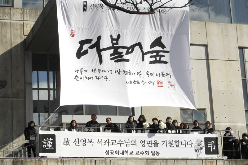 18일 서울 항동 성공회대학교에서 엄수된 고(故) 신영복 성공회대 석좌교수의 영결식을 마치고 고인의 영정과 유해가 운구 차량에 탑승 떠나는 모습을 조문객들이 끝까지 지켜보고 있다.