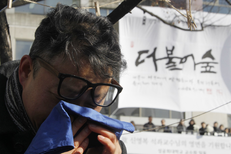 18일 서울 항동 성공회대학교에서 엄수된 고(故) 신영복 성공회대 석좌교수의 영결식을 마치고 고인의 영정과 유해가 운구 차량에 탑승 떠나는 모습을 보던 조문객이 끝내 눈물을 흘리고 있다.