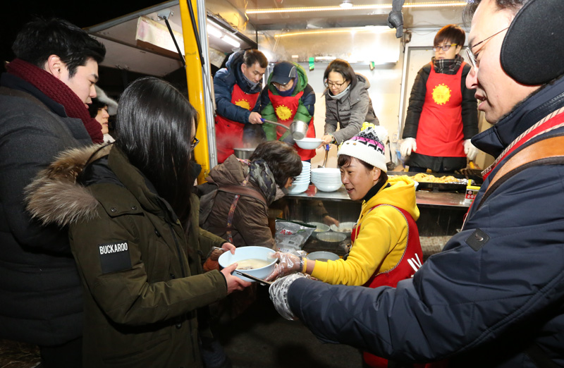 민족대명절인 설 연휴 시작인 6일 저녁 서울 종로구 옛 주한 일본대사관 앞 소녀상에서 소녀상 지키기 한일합의무효 6차 토요시위에 나타난 협동조합 밥통 밥차 회원들과 세월호 유가족들과 자원봉사자들이 배식을 하고 있다.