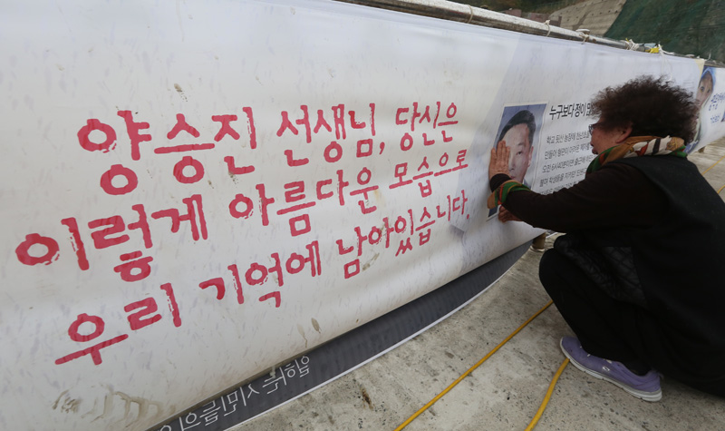 전남 진도군 팽목항 방파제에서 세월호 미수습자 양승진 씨 어어니가 아들 사진을 어루만지며 오열하고 있다.