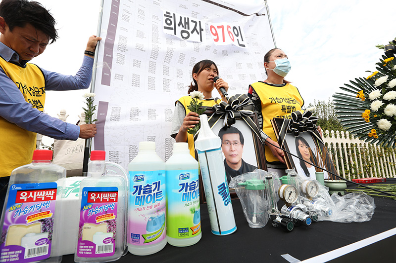 7일 오후 서울 여의도 국회 정문 앞에서 열린 가습기살균제 희생자 고(故) 김명천, 김연숙 씨의 추모제 및 기자회견에서 김명천 씨의 딸 김미란 씨가 아버지의 영정을 들고 발언을 하고 있다.
