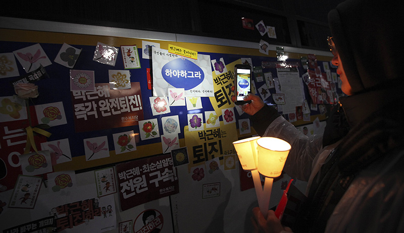 박근혜 대통령의 퇴진을 촉구하는 5차 촛불집회가 열린 26일 오후 서울 종로구 청운효자동 주민센터 인근에서 시민이 경찰버스에 붙여진 스티커를 핸드폰에 담고 있다.