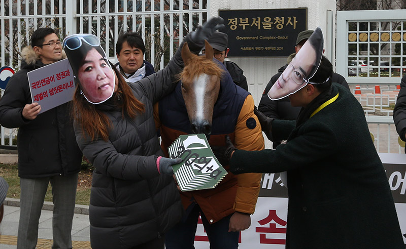 공적연금강화국민행동을 비롯한 시민단체 관계자들이 지난 14일 서울 세종로 정부서울청사 앞에서 삼성-최순실 게이트 관련 국민연금 손해배상소송 1만2000명 국민청원 기자회견을 열고 국민연금 손해끼친 이들에게 책임을 묻겠다며 퍼포먼스를 하고 있다.