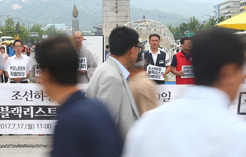 조선하청노동자 대량해고저지를 위한 시민사회대책위원회 소속 회원들이 17일 오전 서울 종로구 광화문광장에서 현대중공업 하청노동자들의 고공농성 100일을 맞아 기자회견을 열고 조선하청노동자 대량해고 중단과 블랙리스트 철폐 촉구했다.