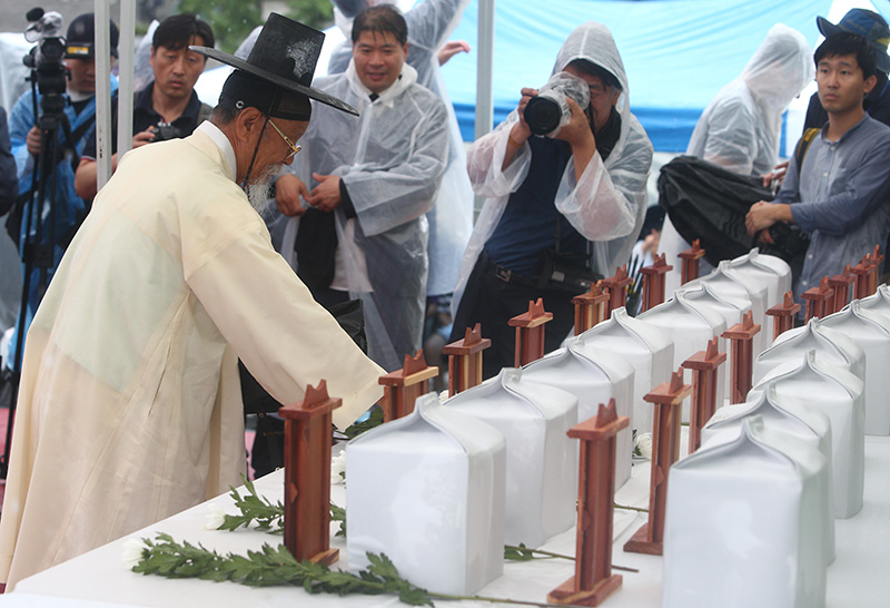 지난 2017년 8월 15일 오전 서울 광화문광장에서 열린 일제강제징용희생자 유해봉환 국민추모제에서 참석자가 헌화하고 있다.