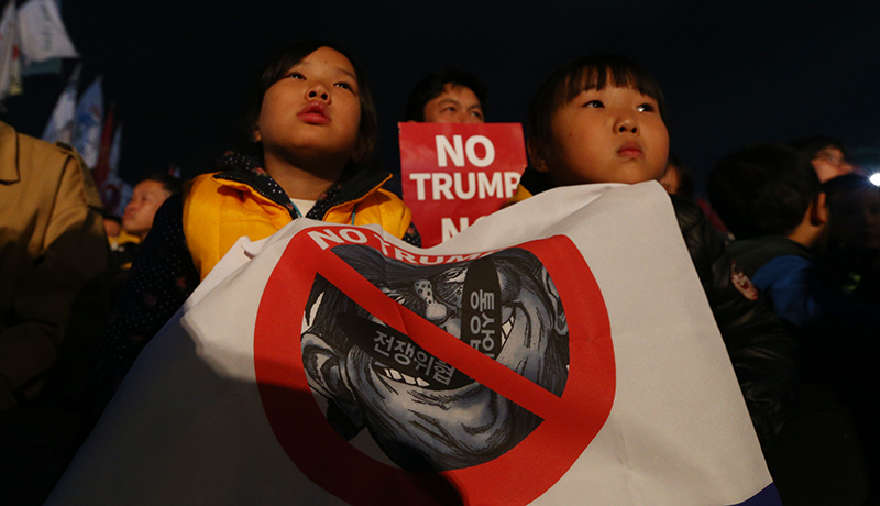 트럼프 미국 대통령이 방한한 7일 저녁 서울 광화문 광장에서 전쟁반대 평화실현 국민촛불에서 참가자들이 촛불과 트럼프 규탄 피켓을 들고 있다.