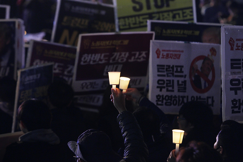 트럼프 미국 대통령이 방한한 7일 저녁 서울 광화문 광장에서 전쟁반대 평화실현 국민촛불에서 참가자가 촛불을 밝히고 있다.