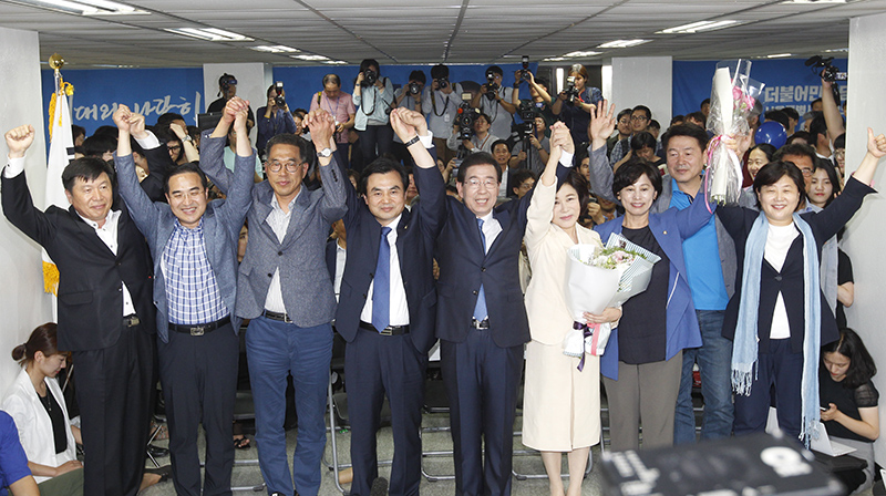 더불어민주당 박원순 서울시장 후보와 부인 강난희 여사 캠프 관계자들이 6.13지방선거 투표일인 13일 밤 당선이 유력해지자 서울 종로구 안국동 선거캠프에서 전달 받은 꽃다발을 받고 두손을 들어 인사하고 있다.