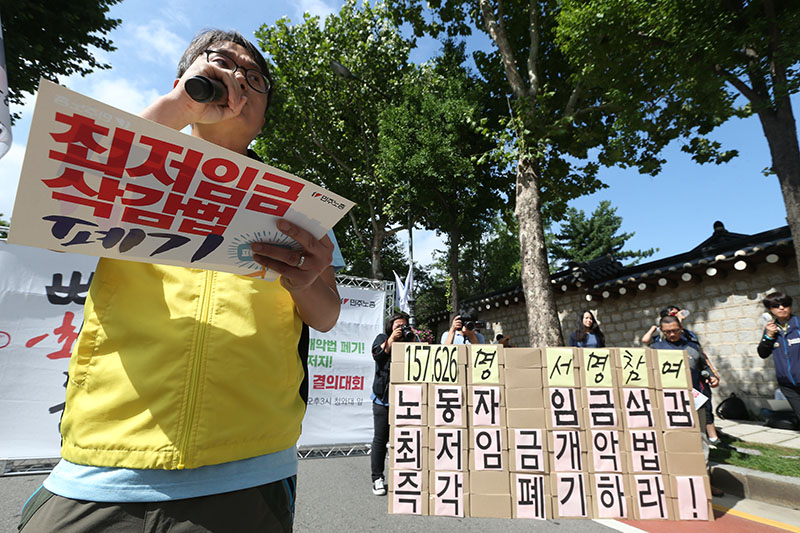 13일 오후 서울 종로구 청와대 사랑채 앞에서 열린 최저임금개악 폐기, 임금개악 저지 민주노총 결의대회에서 한 마트 노동자가 최저임금삭감법 폐기 촉구 발언을 하고 있다