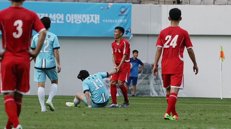 11일 오후 서울월드컵경기장에서 열린 남북노동자통일 축구대회 한국노총 대표팀과 북측 조선직업총동맹 건설노동자팀의 경기에서 건설노동자팀 선수가 한국노총 선수를 일으켜주고 있다.