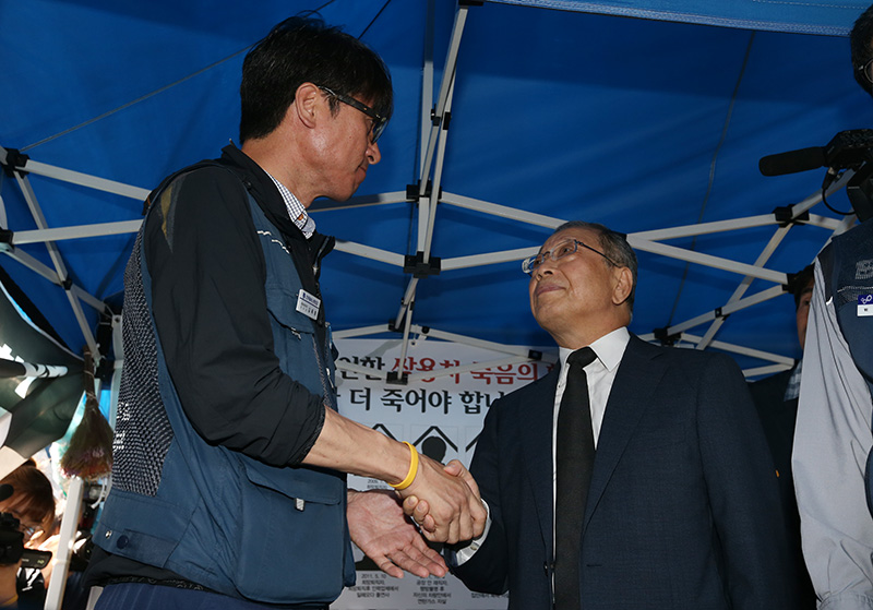 최종식 쌍용자동차 사장이 13일 오후 서울 중구 덕수궁 대한문 앞에 마련된 쌍용차 해고자·가족 희생자 분향소를 찾아 조문을 마친 뒤 김득중 금속노조 쌍용차지부장과 악수하고 있다.
