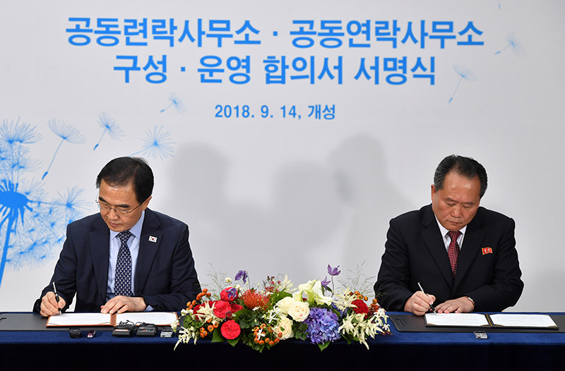 남측 조명균 통일부 장관과 북측 리선권 조국평화통일위원회 위원장이 14일 오전 북한 개성공단 내 남북공동연락사무소 개소식에서 구성·운영에 관한 합의서에 서명을 하고 있다.