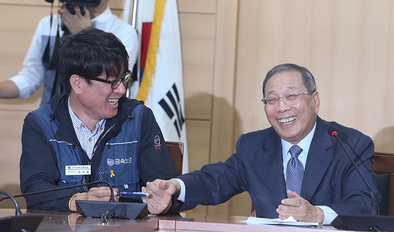 김득중 쌍용자동차지부장(왼쪽부터), 최종식 쌍용자동차 사장이 14일 서울 종로구 경제사회노동위원회에서 열린 쌍용자동차 해고자 복직 합의안 발표 기자회견에서 손을 잡고 환하게 웃고 있다. 쌍용차 노사는 내년 상반기까지 남아있는 해고자 119명을 모두 복직시키기로 합의하고 9년을 끌어온 쌍용차 사태의 마침표를 찍다.