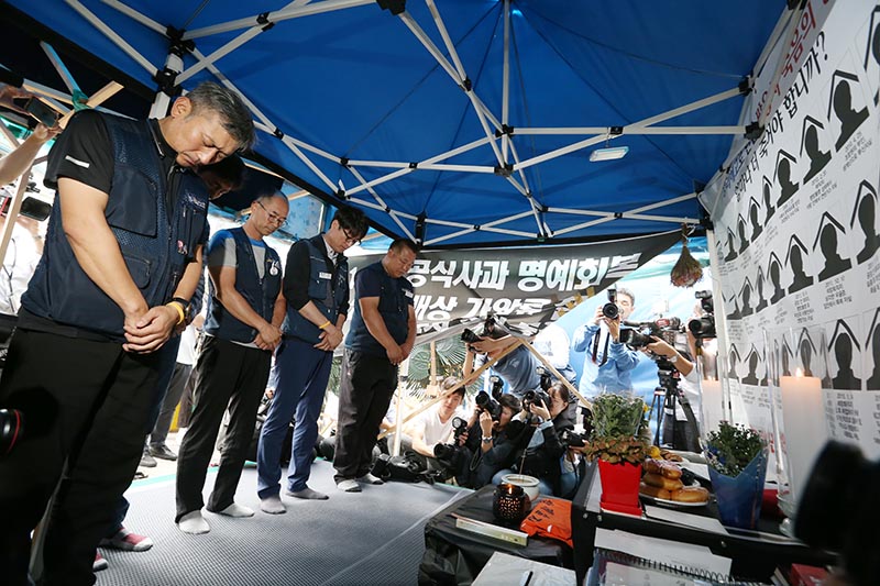김득중 금속노조 쌍용자동차지부장과 조합원들이 14일 서울 중구 덕수궁 대한문 앞 희생자 분향소에서 열린 해고자 복직 관련 기자회견을 마친 뒤 쌍용차 희생자분들에게 꽃 화분을 바치고 묵념을 하고 있다.