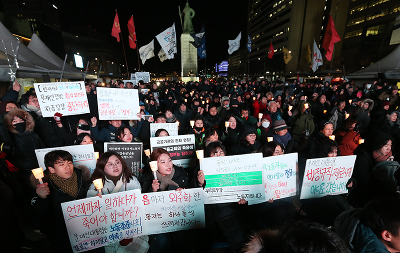 태안화력발전소에서 비정규직 노동자로 일하다 사고로 숨진 김용균씨(24)를 추모하는 촛불집회가 13일 오후 서울 광화문 광장에서 진행 참석자들이 촛불을 밝히고 있다.