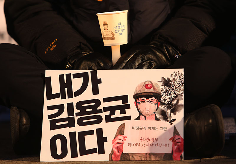 김용균 시민대책위원회 주최로 29일 오후 서울 광화문광장에서 열린 2차 범국민 추모제에서 한 참석자가 촛불을 밝히고 있다.