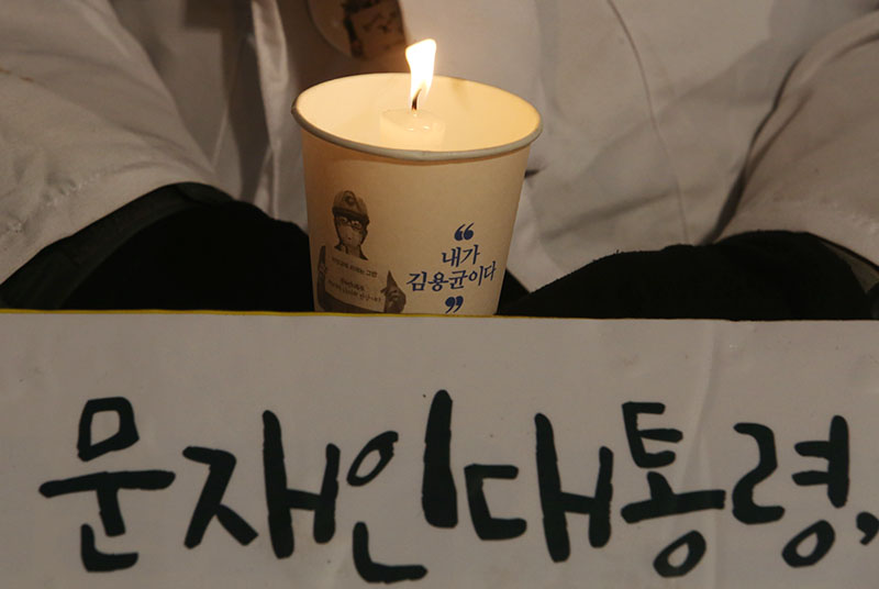 김용균 시민대책위원회 주최로 29일 오후 서울 광화문광장에서 열린 2차 범국민 추모제에서 고 김용균 씨의 어머니 김미숙 씨와 참석자들이 촛불을 밝히고 있다.