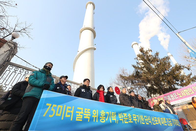 7일 오전 서울 양천구 서울에너지공사 열병합발전소 앞에서 열린 75m 굴뚝 위 홍기탁 전 파인텍 지회장, 박준호 사무장의 무기한 단식 선포에 따른 긴급 기자회견에서 참석자들이 단식 중단과 빠른 해결을 촉구하며 구호를 외치고 있다
