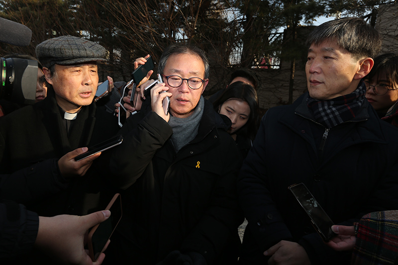 7일 오전 서울 양천구 서울에너지공사 열병합발전소 앞에서 열린 75m 굴뚝 위 홍기탁 전 파인텍 지회장, 박준호 사무장의 무기한 단식 선포에 따른 긴급 기자회견에 앞서 나승구 천주교 정의구현사제단 신부가 농성 중인 홍기탁 금속노조 파인텍지회 전 지회장, 박준호 사무장과 통화를 하고 있다. 금속노조 파인텍지회 홍기탁 전 지회장과 박준호 사무장은 이곳의 75m 높이 굴뚝에 올라 422일째 농성 중이며 421일 차인 6일 물도 안먹으면 무기한 고공 단식에 돌입했다