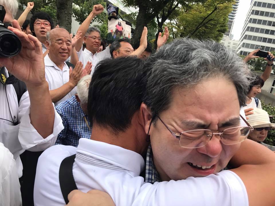 일본 오사카(大阪)지방재판소가 28일 일본 정부의 조선학교 고교 수업료 무상화 배제 조치가 위법하다며 원고 승소 판결했다. 환호하는 사람들과 감격의 포옹을 하는 오사카 무상화 연락회 공동대표 후지나카 다케시씨.