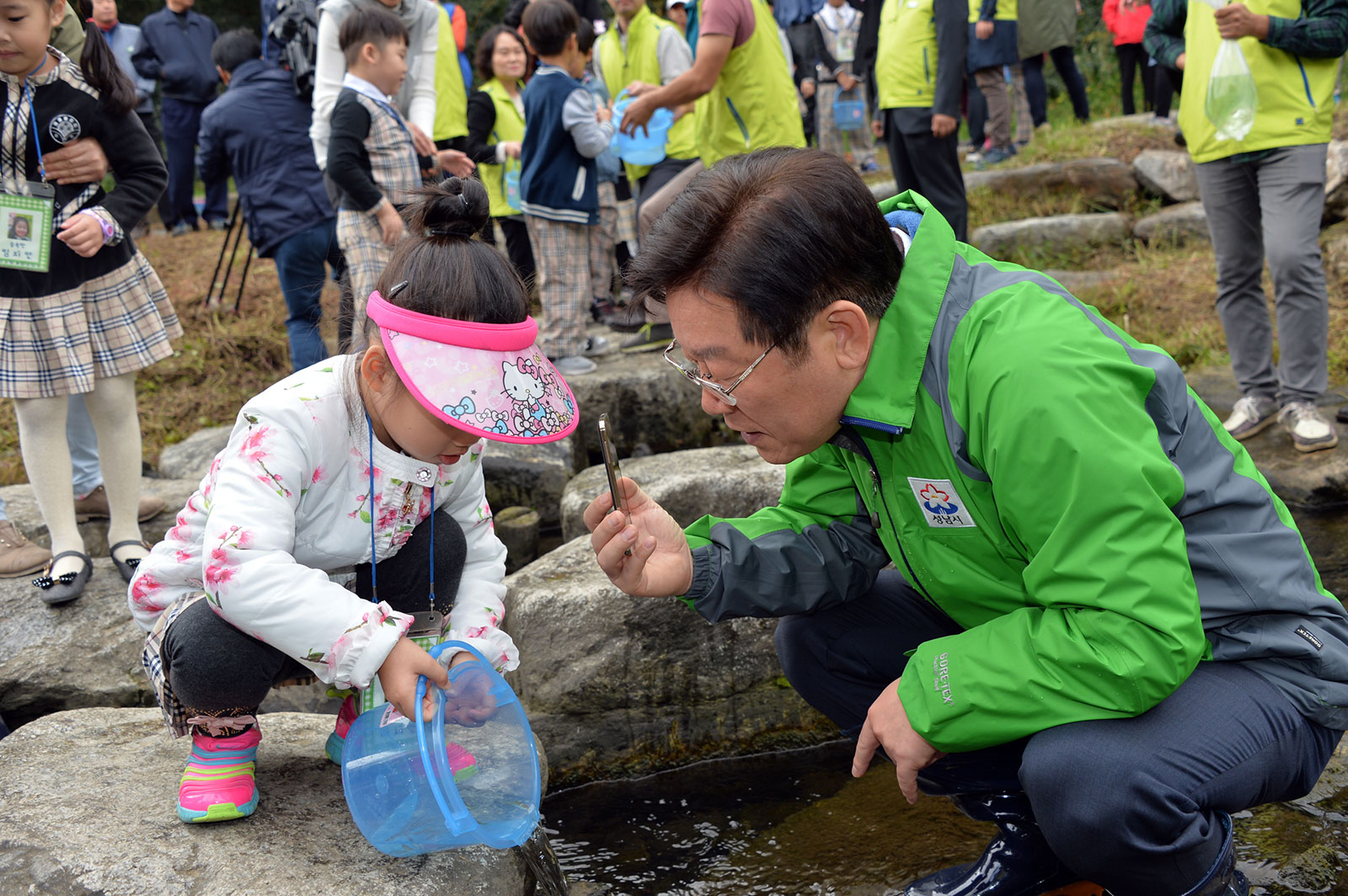 여수천에 토종 민물고기 방류 중인 어린이와 이재명 성남시장