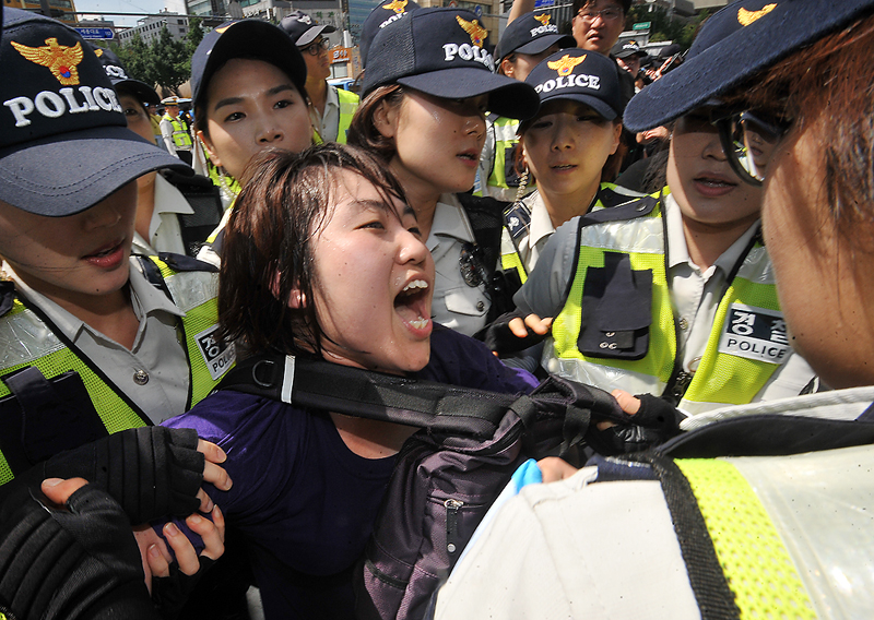 여러명의 경찰들에게 둘러싸인 시위대
