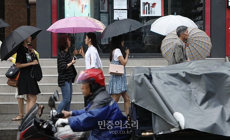 전국에 대부분 지역에 비가 내리고 있는 2일 오전 서울 마포구 홍대입구역 인근에서 시민들이 우산을 쓴 채 출근길을 재촉하고 있다.