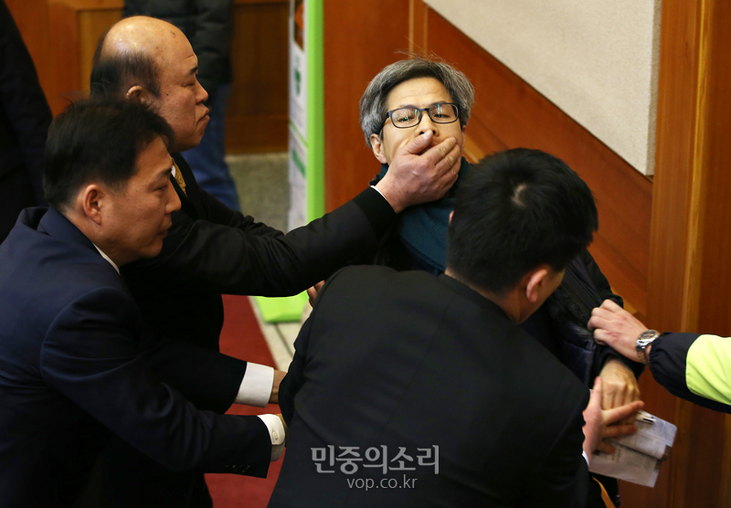 19일 오전 서울 종로구 헌밥재판소에서 진행된 통합진보당에 대한 정당해산심판에서 해산 판결이 나자 권영국 변호사가 법정에서 항의하다 끌려나가고 있다.