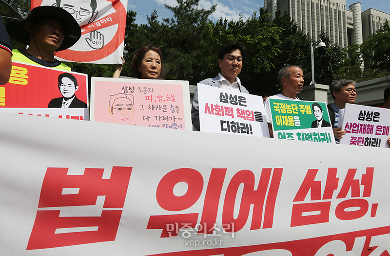 이재용 삼성전자 부회장의 선고공판이 열리는 25일 오전 서울 서초구 서초동 서울지법 앞에서 삼성전자서비스지회, 반올림, 삼성노동인권지킴이가 연 이재용 엄중 처벌 촉구 기자회견에서 삼성 직업병 피해자 가족 김시녀-황상기 씨와 참가자들이 피켓을 들고 있다.