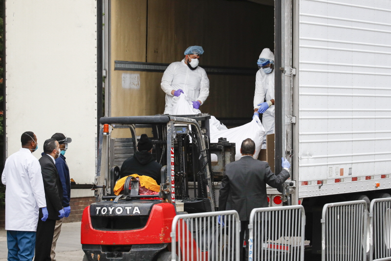 지난달 31일(현지 시간) 미국 뉴욕 브루클린에 있는 한 병원에서 비닐로 싸인 신종 코로나바이러스 감염증(코로나19) 사망자의 시신이 임시영안실로 사용되는 냉동 트럭으로 옮겨지고 있다.