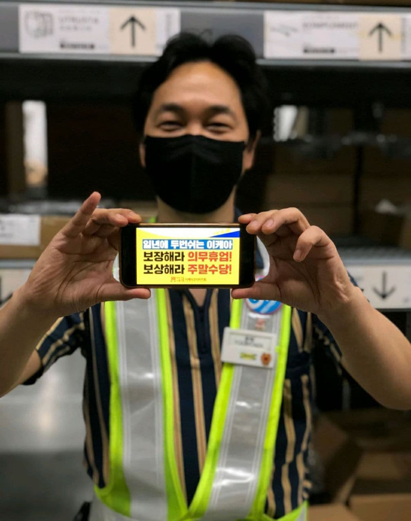 정윤택 마트산업노조 이케아코리아지회 지회장이 투쟁 구호가 적힌 핸드폰 화면을 들고 있는 모습.