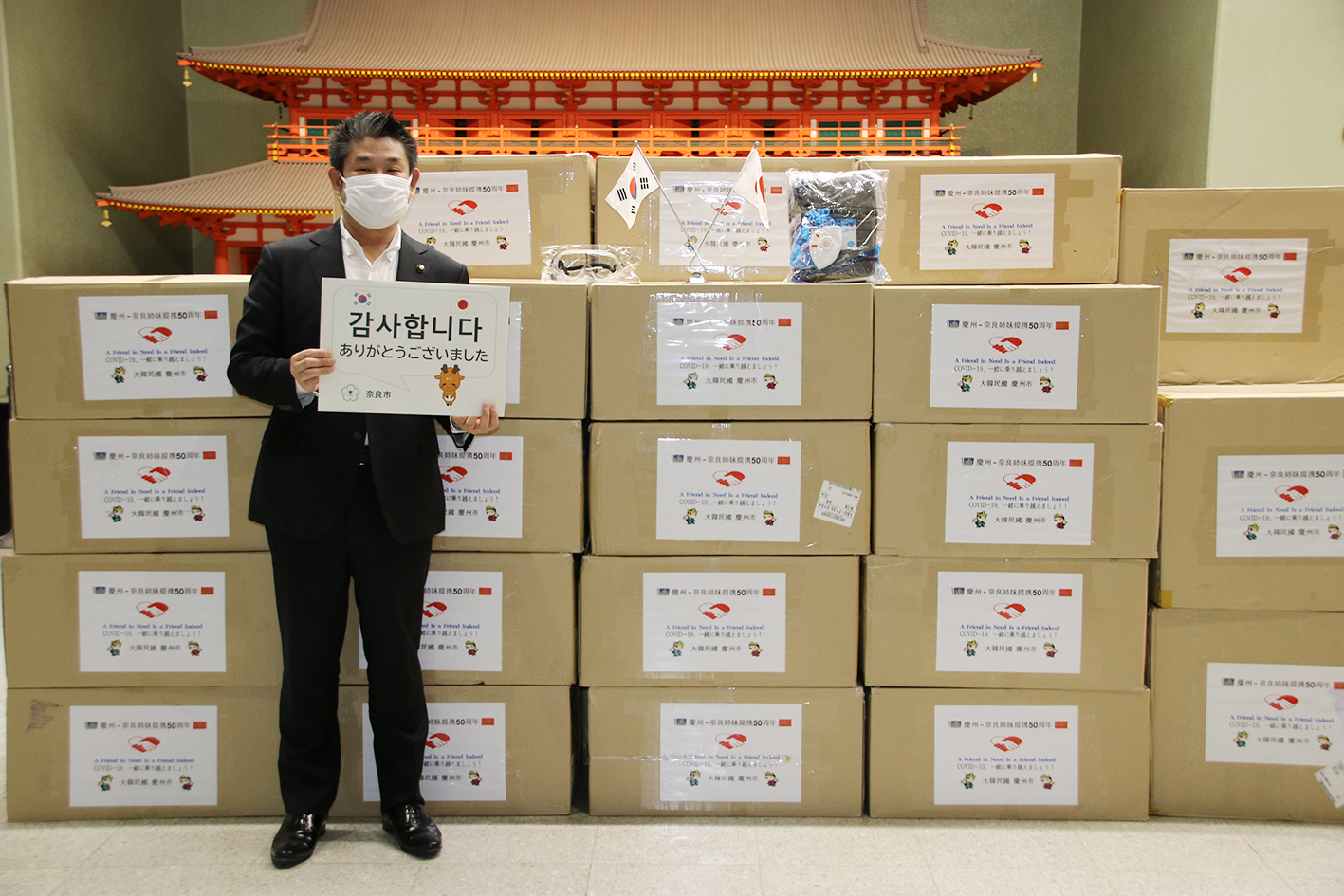 경주시가 보낸 방역물품 앞에서 ‘감사합니다’ 팻말을 들고 있는 나카가와 겐 나라시장